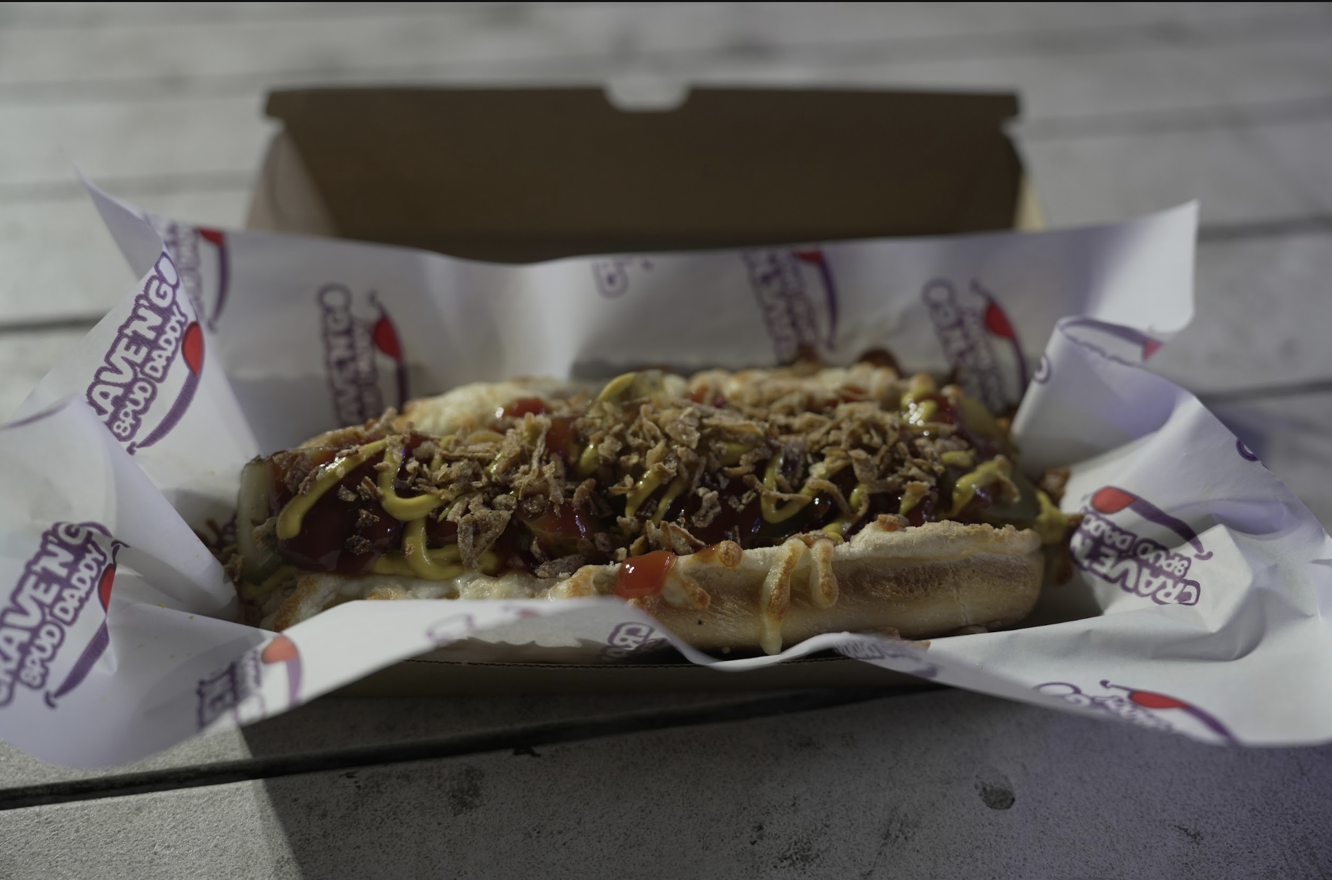 Crave 'N' Go Spud Daddy loaded hot dog with cheese, mustard, ketchup and crispy onions